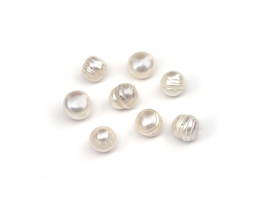 Perlas irregulares con perforación completa.  Blancas